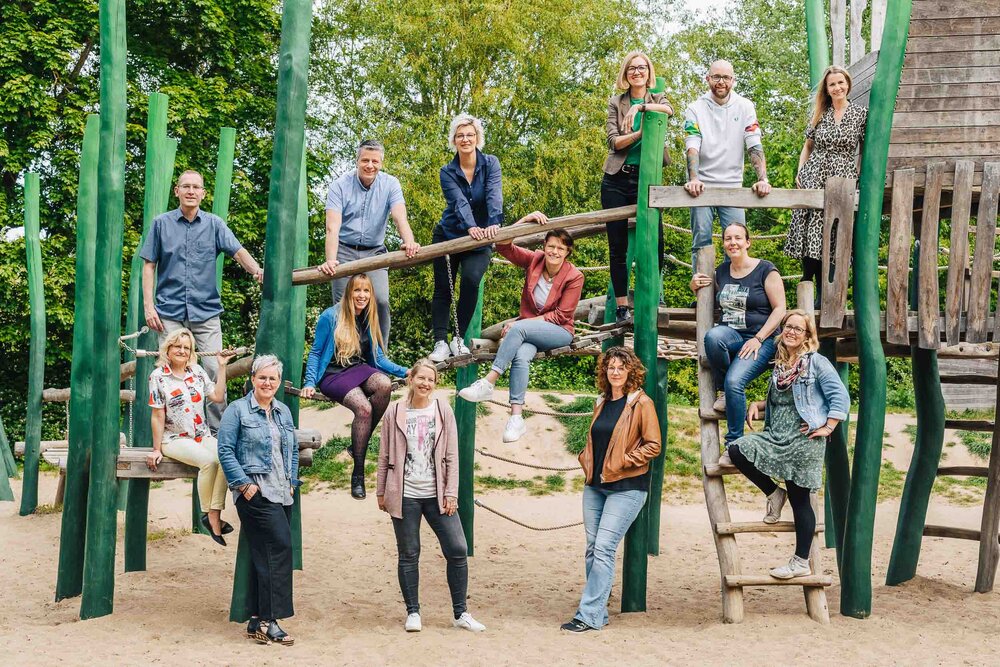 Eine Gruppe von Menschen steht beieinander auf einem Klettergerüst