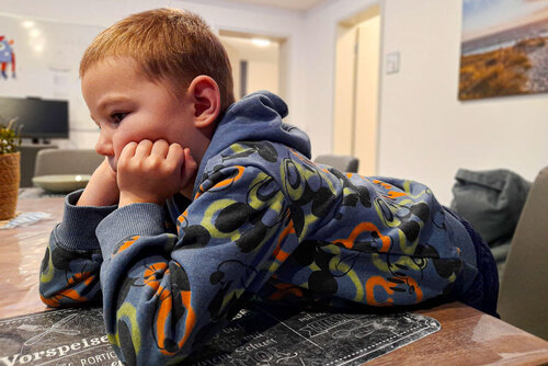 Ein Junge stützt sich auf einen Tisch