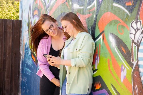 Zwei junge Menschen stehen vor einer bemalten Hauswand in der integrativen Wohngruppe am Ryck