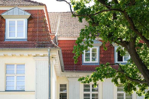 Gebäuderückseite des Annastifs Jarmen mit Fenstern und einem Baum 